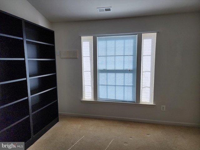 carpeted empty room with visible vents and baseboards