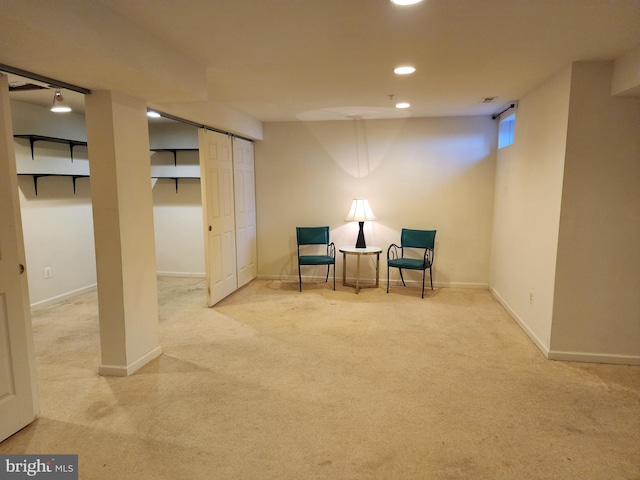 living area featuring baseboards, a barn door, and carpet floors