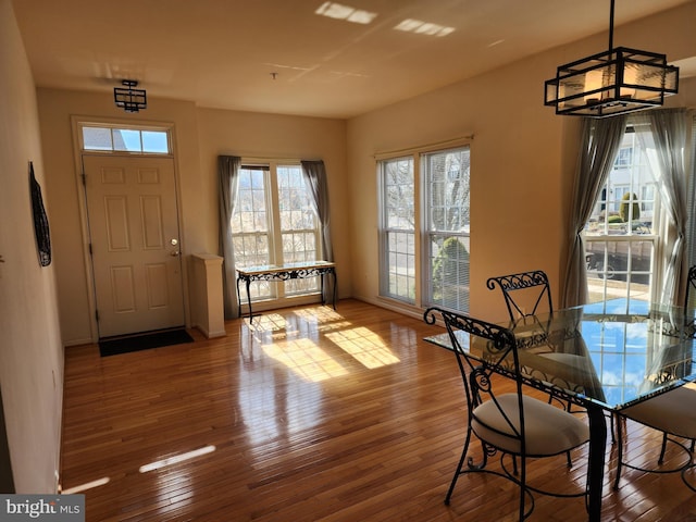 foyer featuring an inviting chandelier, baseboards, and wood-type flooring