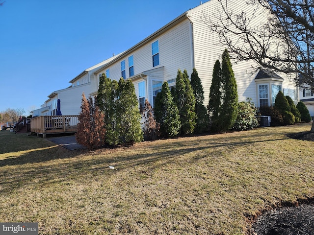 view of side of property with a lawn and a wooden deck