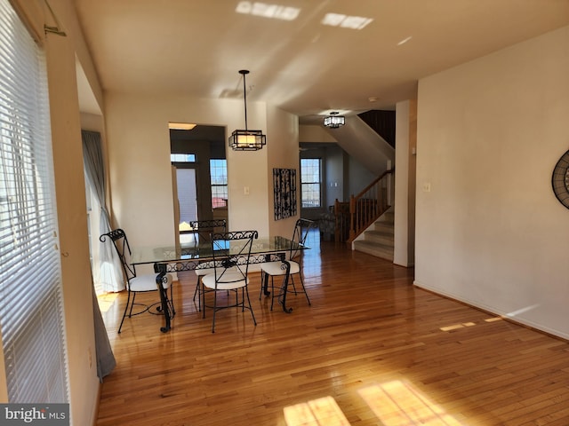 dining room with stairway and wood finished floors