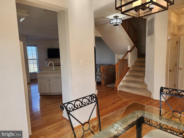 stairway with visible vents and wood-type flooring