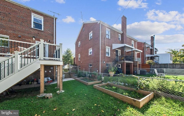 view of yard featuring a vegetable garden, stairs, and fence