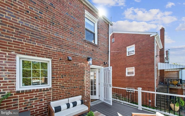 rear view of house with brick siding and a wooden deck