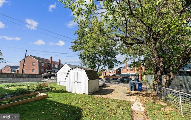 view of yard with a storage unit, an outbuilding, a fenced backyard, a residential view, and a vegetable garden