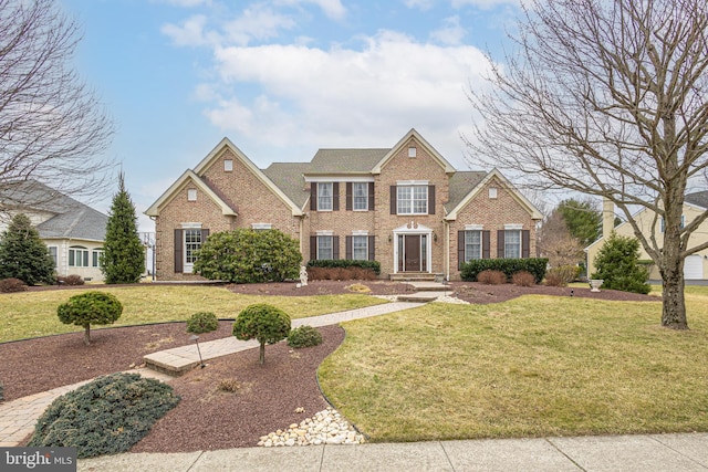 view of front of house featuring brick siding and a front yard