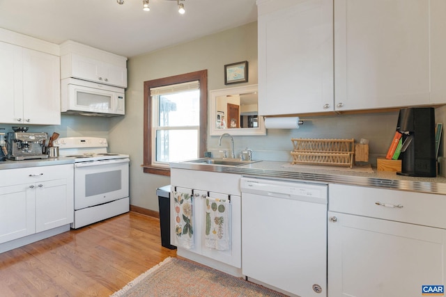 kitchen featuring white appliances, white cabinets, stainless steel countertops, and a sink