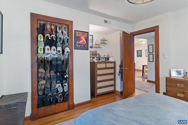 bedroom featuring visible vents, baseboards, and wood finished floors