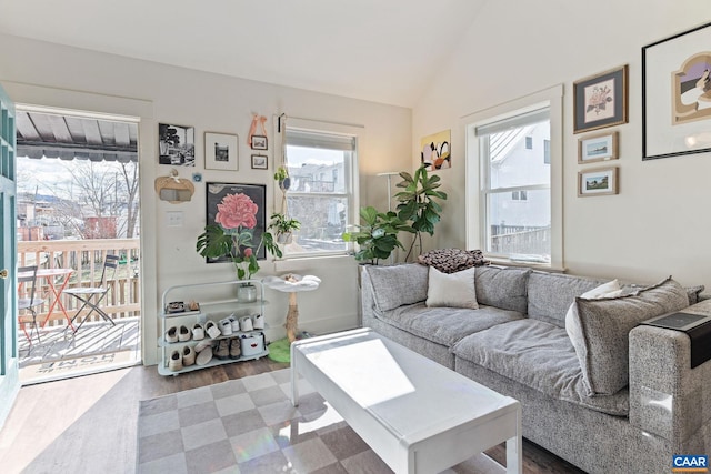 living room featuring plenty of natural light, lofted ceiling, and wood finished floors