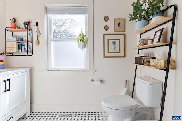 bathroom featuring baseboards, toilet, and vanity