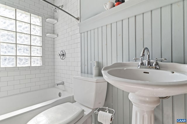 full bathroom featuring toilet, washtub / shower combination, and a sink