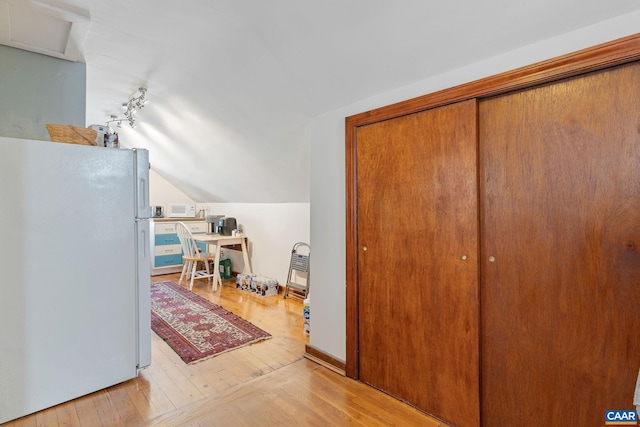 interior space featuring lofted ceiling and light wood-style floors