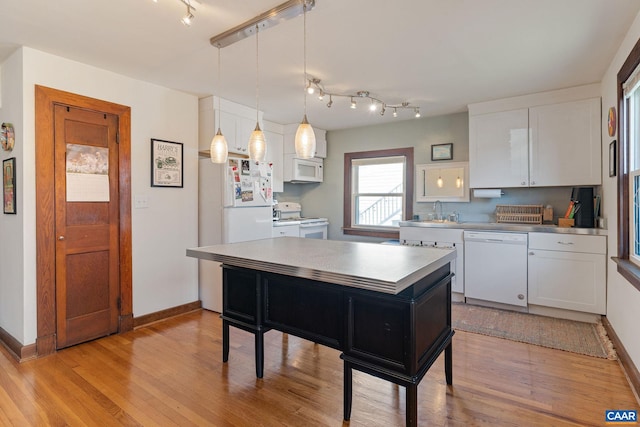 kitchen featuring white cabinets, white appliances, pendant lighting, and light wood-type flooring