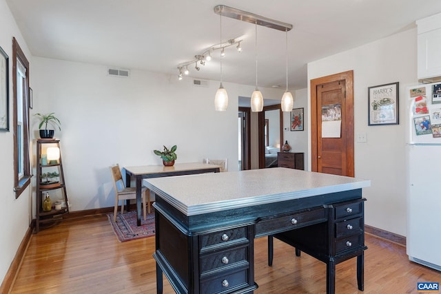 office space featuring baseboards, visible vents, and light wood-type flooring