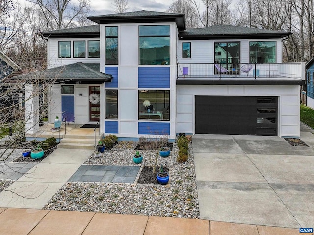 view of front of home with a balcony, driveway, an attached garage, and roof with shingles