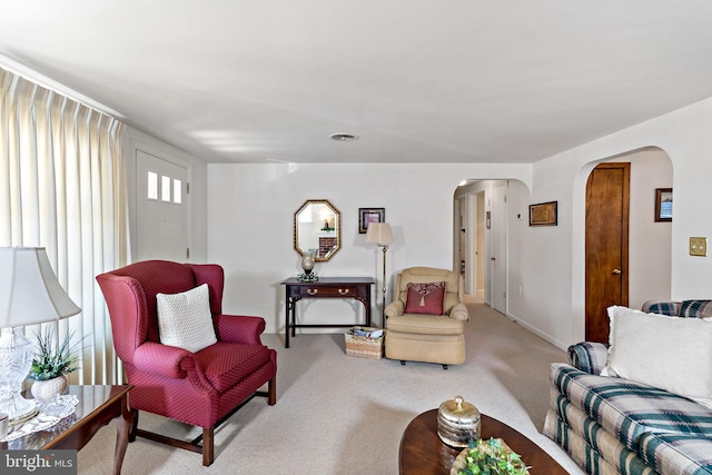 living room featuring carpet and arched walkways