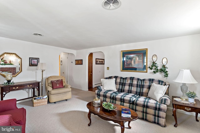 carpeted living room featuring a baseboard heating unit, visible vents, and arched walkways