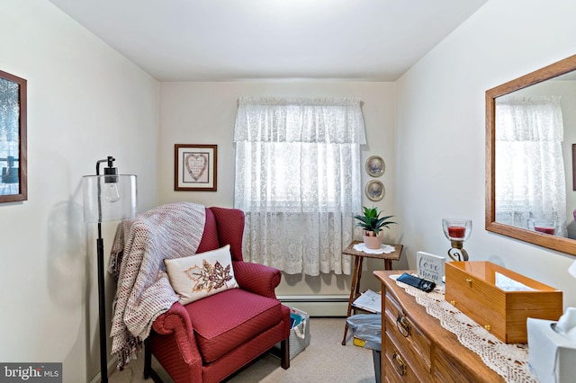 sitting room with baseboard heating and carpet flooring