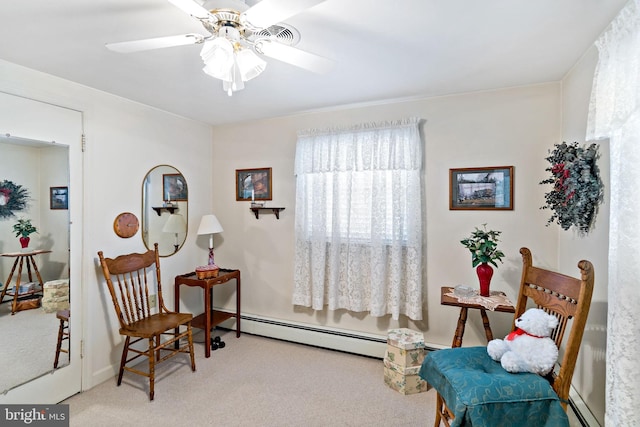 living area featuring carpet flooring, baseboard heating, and ceiling fan