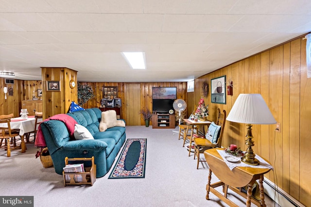 carpeted living room with wood walls and a baseboard heating unit