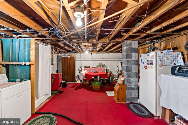 unfinished basement featuring washer / dryer, a heating unit, and freestanding refrigerator