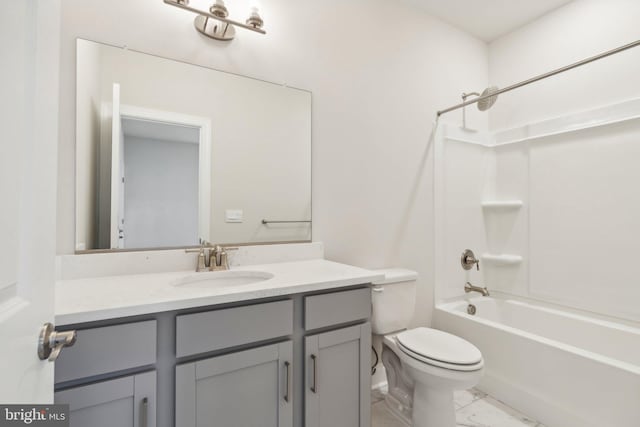 bathroom featuring marble finish floor, toilet, vanity, and bathing tub / shower combination