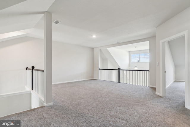 carpeted empty room with baseboards, visible vents, and ceiling fan