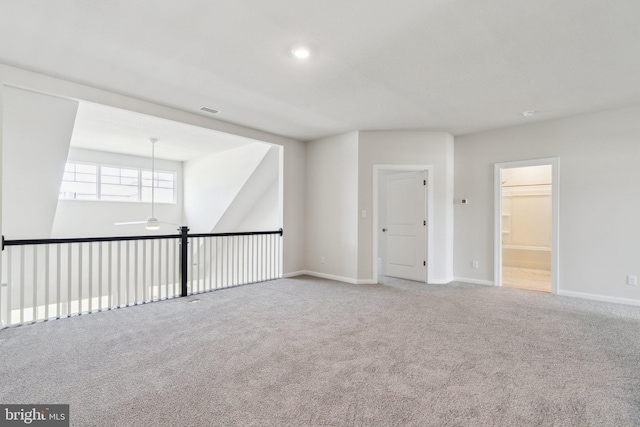 carpeted spare room featuring visible vents, baseboards, and a ceiling fan