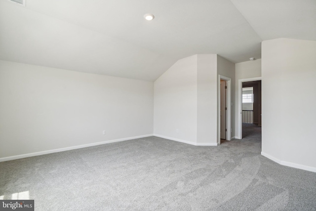 additional living space featuring vaulted ceiling, carpet, and baseboards