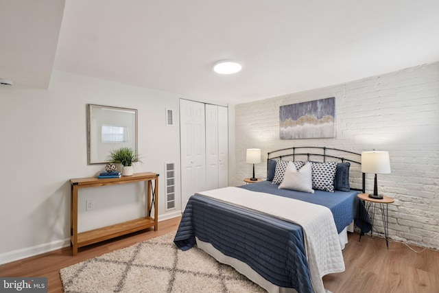 106 15th St SE, Washington, DC 20003 - bedroom with wood finished floors, a closet, and brick wall