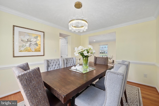 dining room with wood finished floors and ornamental molding