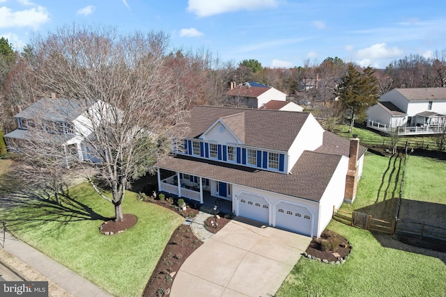 view of front of property featuring a front lawn, fence, roof with shingles, concrete driveway, and an attached garage