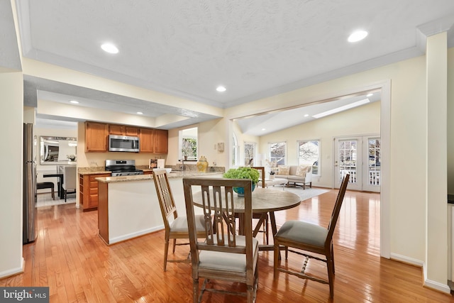 dining area with recessed lighting, light wood-style floors, and vaulted ceiling