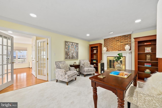 living room with recessed lighting, french doors, crown molding, and a brick fireplace