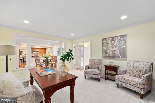 living room featuring recessed lighting, light colored carpet, ornamental molding, and ornate columns