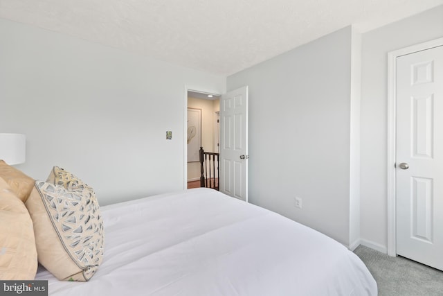 carpeted bedroom with baseboards and a textured ceiling