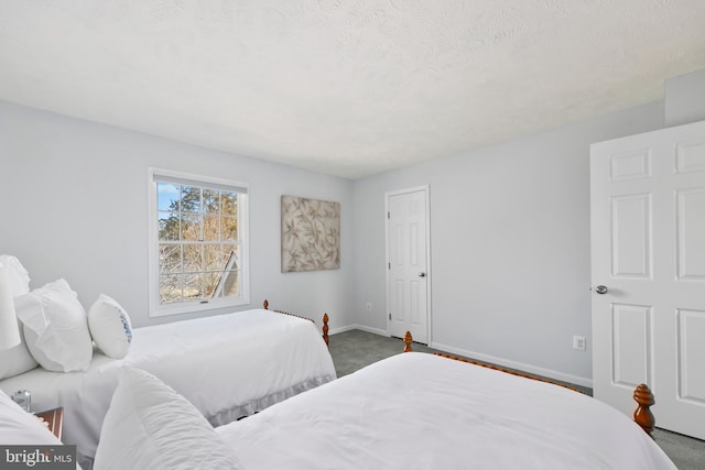 bedroom with baseboards, carpet, and a textured ceiling