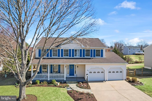 colonial home featuring fence, concrete driveway, a front yard, covered porch, and a garage