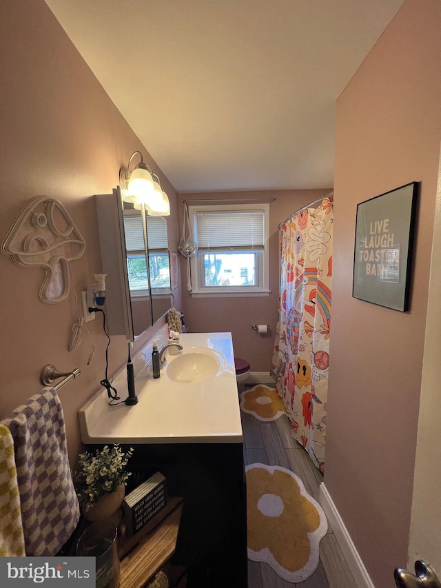 full bathroom featuring a shower with shower curtain, toilet, wood finished floors, and vanity