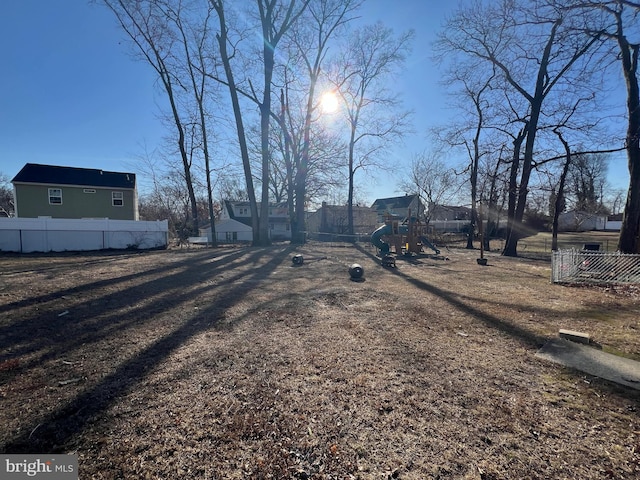 view of yard featuring playground community and fence