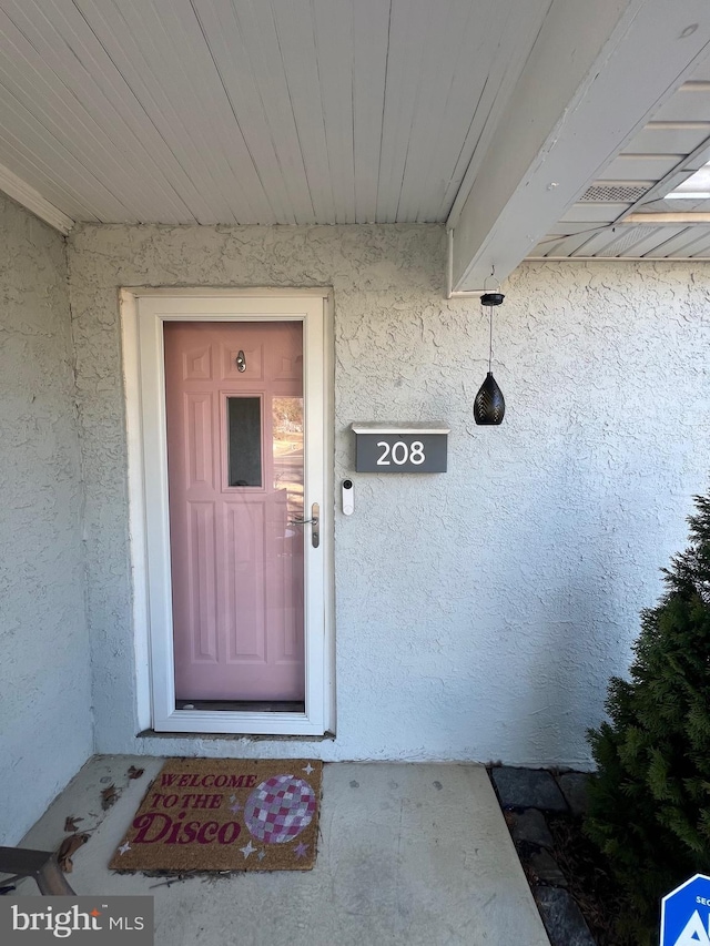 entrance to property with stucco siding