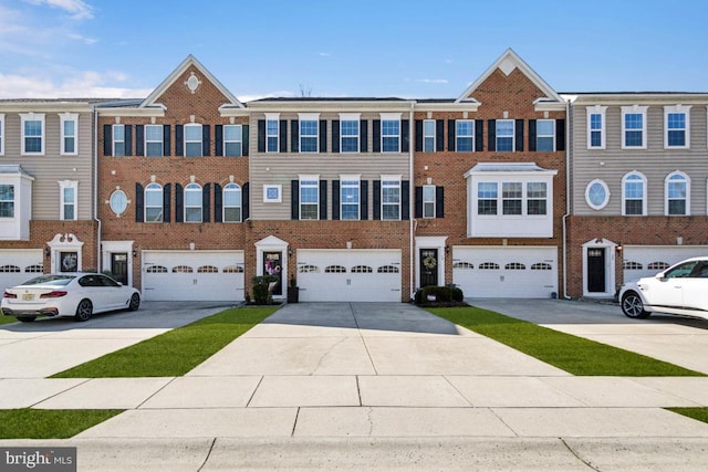 multi unit property featuring brick siding, driveway, and a garage