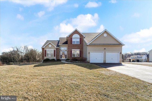 traditional-style home featuring a front yard, fence, driveway, a garage, and brick siding