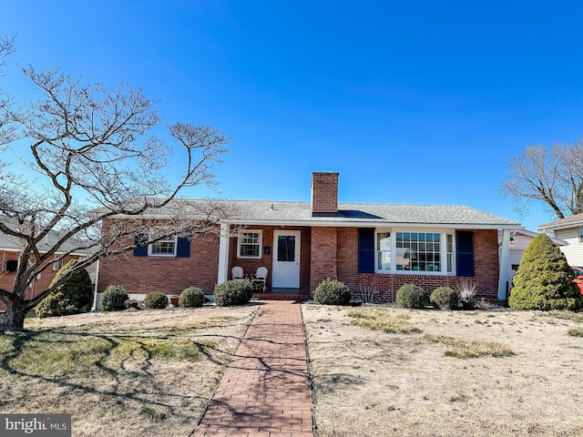 single story home with brick siding and a chimney