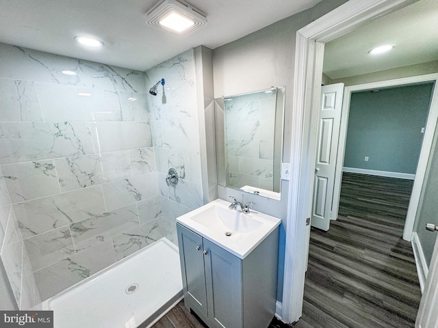 bathroom featuring vanity, wood finished floors, baseboards, recessed lighting, and a stall shower