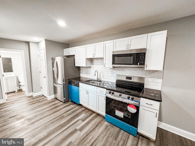 kitchen with white cabinets, appliances with stainless steel finishes, and a sink