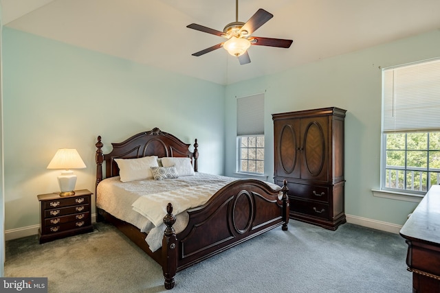 carpeted bedroom with multiple windows, a ceiling fan, and baseboards