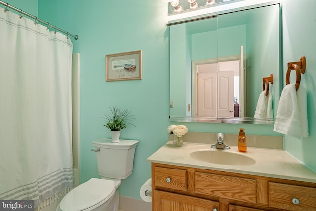 bathroom featuring a shower with shower curtain, toilet, and vanity