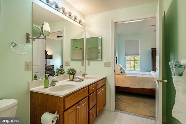 bathroom with double vanity, toilet, ensuite bath, and a sink