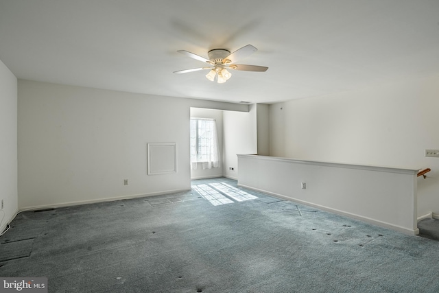 carpeted empty room with baseboards and a ceiling fan